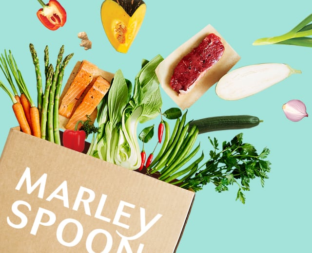 Marley Spoon Kochbox mit frischen Zutaten, die aus der Box fliegen